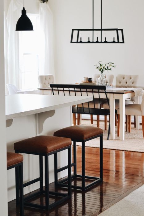 three brown-topped square bar stools with black legs featured in a reviewer's home