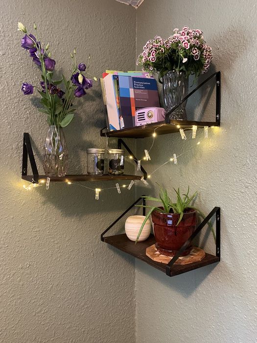 A reviewer's photo showing three industrial shelves mounted on a wall