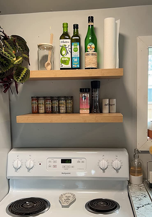 A reviewer shows off their kitchen with wooden shelves installed.
