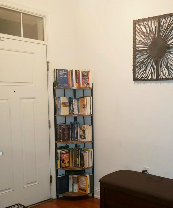 A wide-angle shot of the product positioned beside a door, with books neatly arranged on every shelf