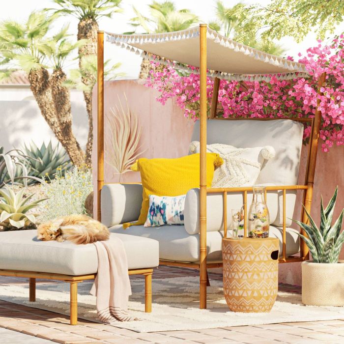 white outdoor chair with a canopy trimmed with white tassels
