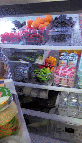 A gif showing a fridge neatly arranged with clear bins.