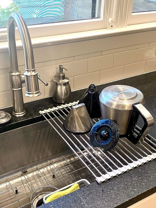 A reviewer places dishes on the over-the-sink drying rack.