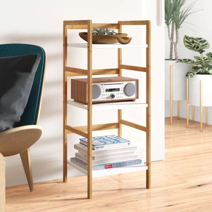 The three-tier solid wood bookshelf featuring books, plants, and a stereo on display