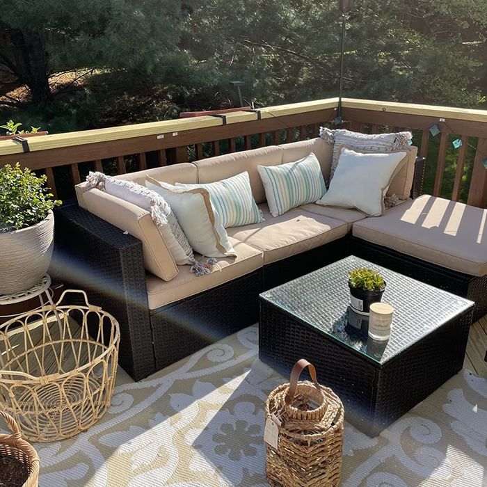 Reviewer photo featuring a sectional with cream cushions tucked into a corner of an outdoor deck, surrounded by plants and decorative items.