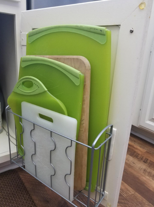 Another reviewer using the organizer to store five cutting boards in an orderly manner.