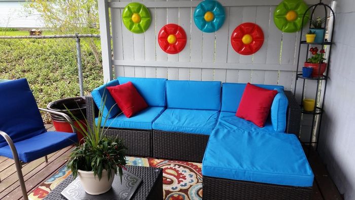 Reviewer photo of a sectional with blue cushions placed on a covered deck.