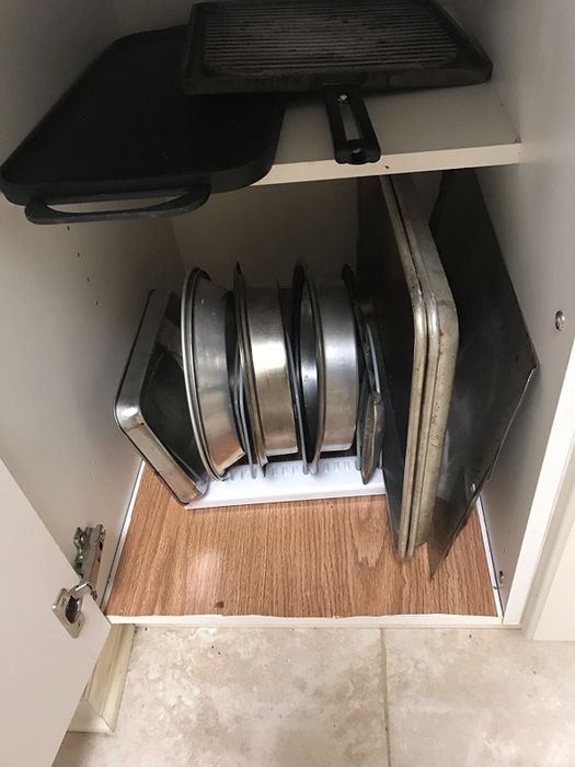 A reviewer's neatly organized cabinet after using a pots and pans holder.