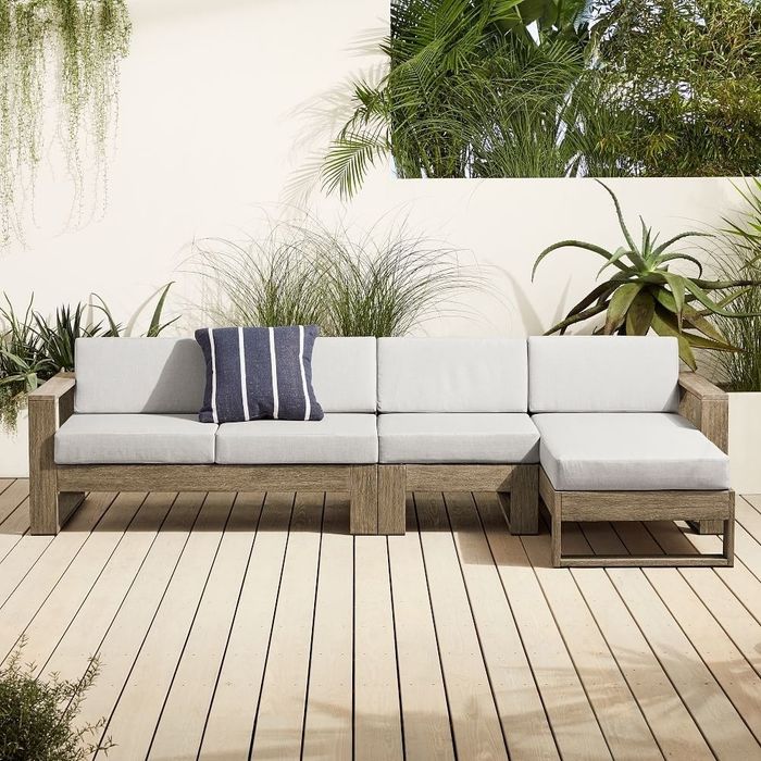 Long, beige sectional sofa with a chaise lounge, placed on a deck.