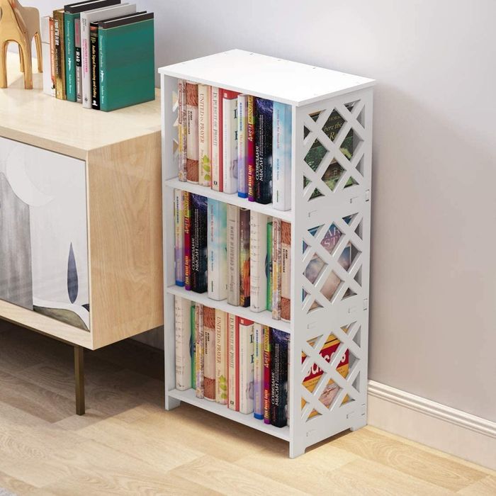 A three-tier white bookcase with lattice detailing, filled with books