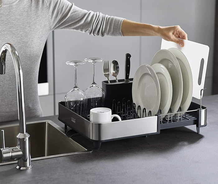 The extended dish rack filled with clean plates, glasses, and silverware.