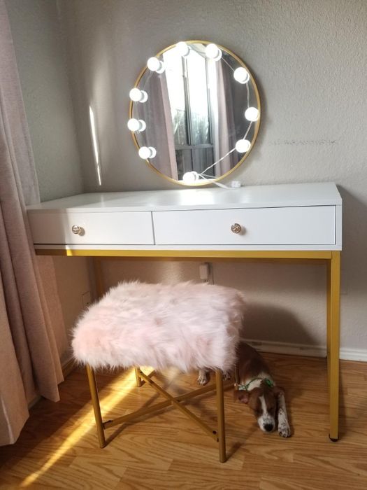 the desk repurposed as a vanity, with a puppy lounging beneath it