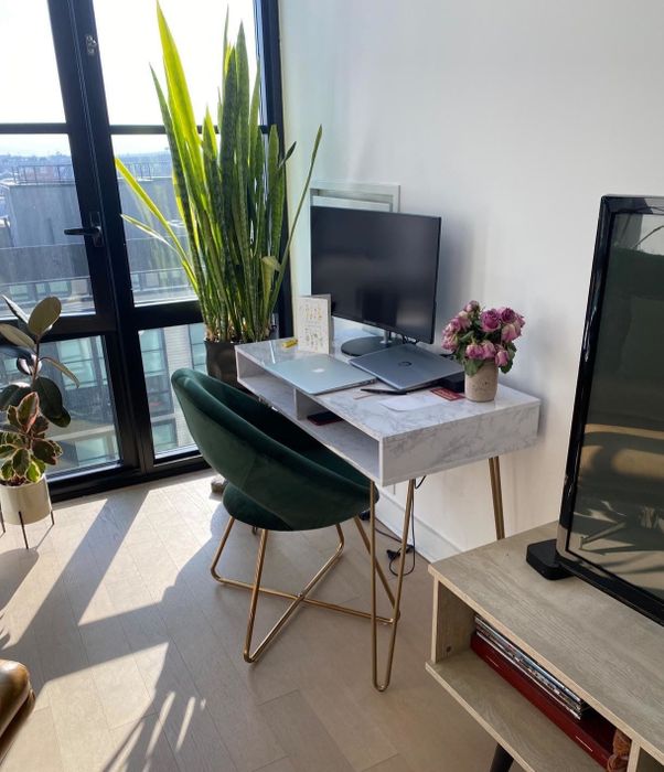 A reviewer's desk tucked into the corner of their living room, blending seamlessly with the space