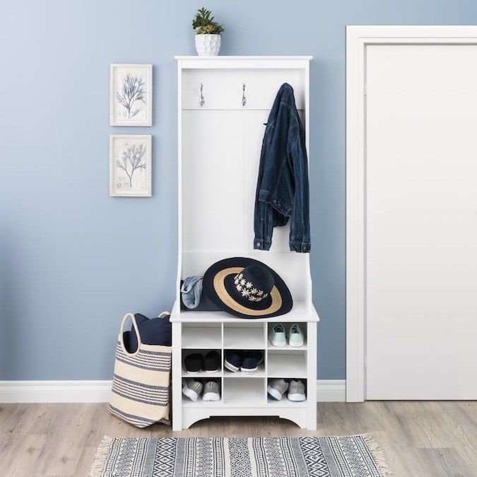 An entryway shelf filled with shoes, coats, hats, and more