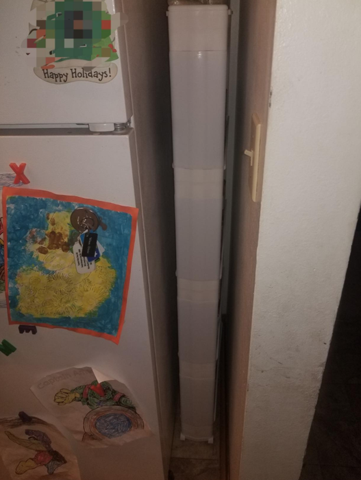 A reviewer's shelf tucked between the fridge and wall