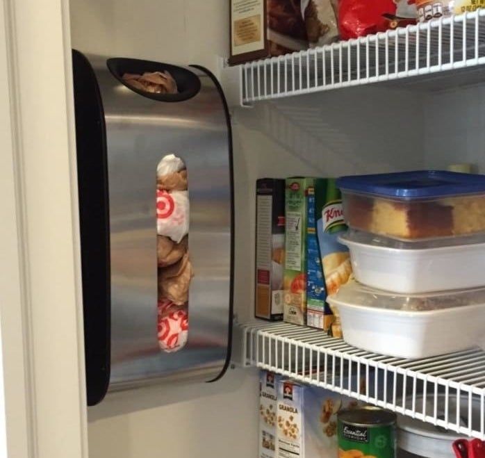 A reviewer’s photo showing a sleek stainless steel dispenser mounted on a pantry wall, with circular and rectangular openings for easy bag retrieval.