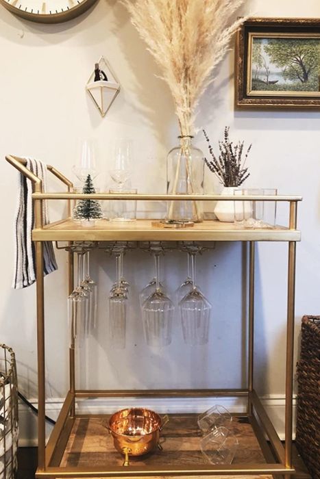 A reviewer's bar cart with gold wineglass racks mounted underneath.