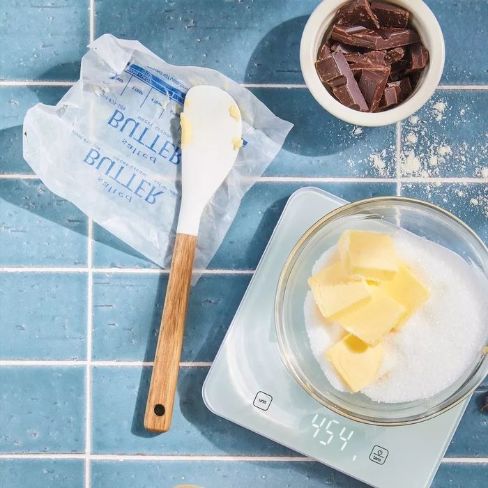 Butter, sugar, and chocolate neatly placed on a kitchen scale, featuring a wrapper marked