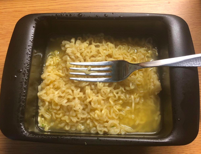 A reviewer enjoying ramen straight from the Rapid Ramen Cooker