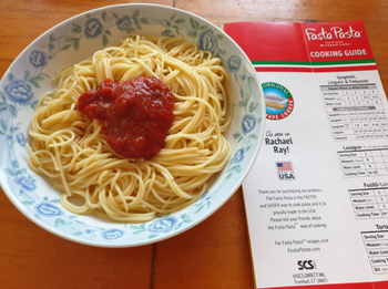 A plate of spaghetti topped with tomato sauce, accompanied by a Fasta Pasta cooking guide that features Rachael Ray's mention and cooking times for various pasta types