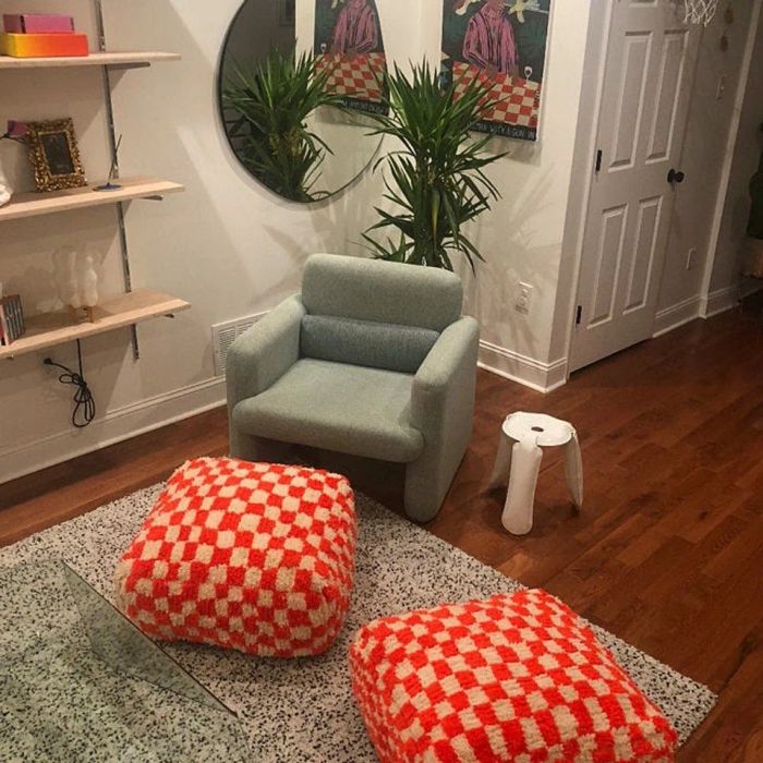 Two red and tan poufs being used as ottomans.