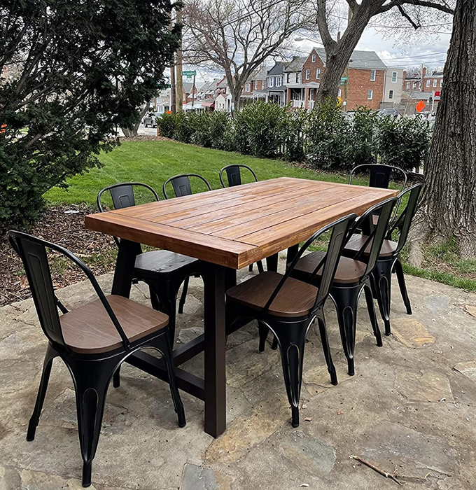 Another reviewer's image showing the outdoor dining table during the day, surrounded by eight brown/black chairs.
