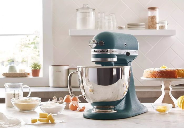 The stylish hunter green KitchenAid stand mixer in action on a kitchen counter, effortlessly mixing dough.