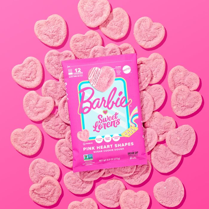 Heart-shaped cookies surrounding a package of Barbie Sweet Lovers cookie dough, all placed on a pink background