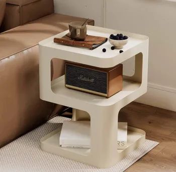Sleek modern side table with a cup, a book, a bowl of blackberries, and a vintage Marshall speaker on top, with neatly stacked books on the lower shelf