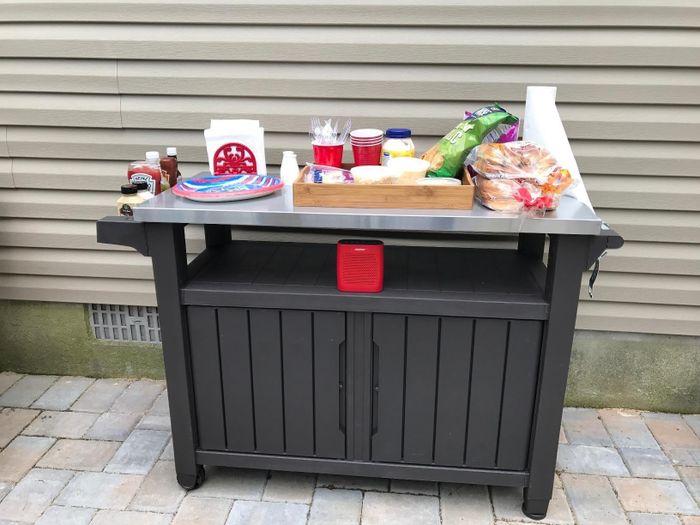 A reviewer's cart holding paper plates, napkins, cups, condiments, and other party essentials.