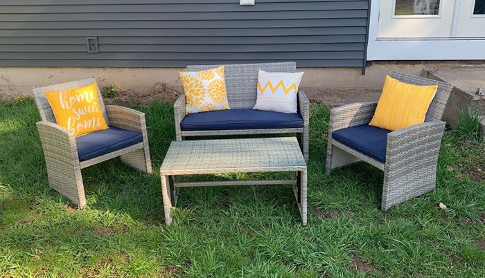 A furniture set is displayed on a grassy area.