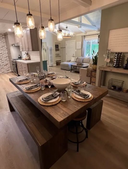 A dinner table completely set with matching benches on each side, ready for a meal.