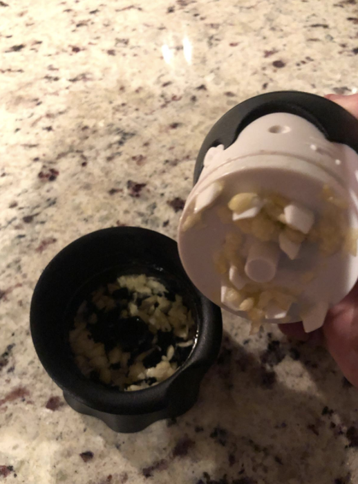The vampire-themed garlic chopper with its top removed, showing the chopped garlic inside