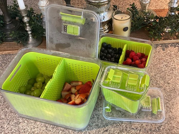 The green containers are displayed on a kitchen countertop