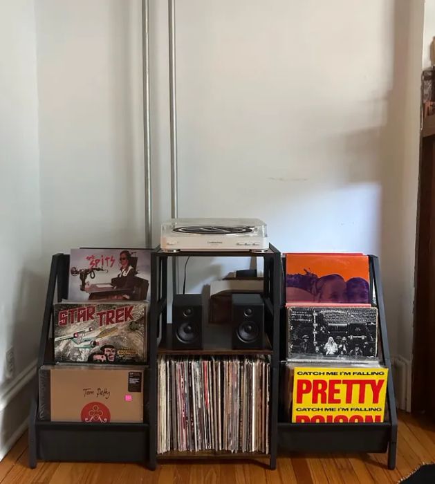 A record display featuring vinyl albums by Tom Petty, Star Trek, and Cat Power. The central shelf holds a turntable and speakers. The article focuses on music-related shopping.