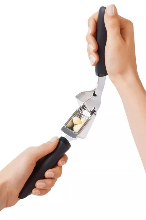 The garlic press in action, about to crush three cloves of garlic.