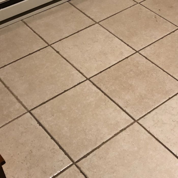 A reviewer’s photo of a tiled floor before using grout cleaner