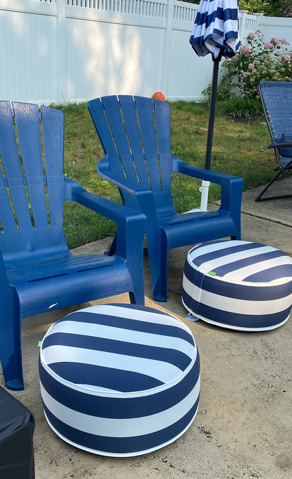 Another reviewer's photo showing two navy and white striped inflatable ottomans placed in front of two patio chairs.