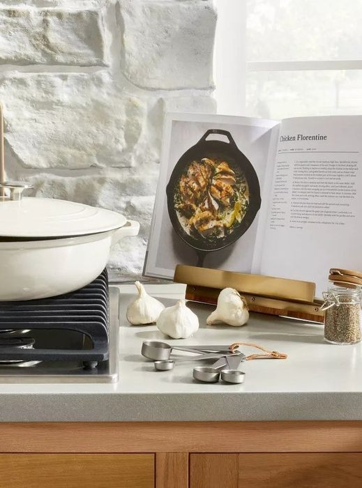 A cookbook holder placed on a kitchen counter, securely holding a cookbook.