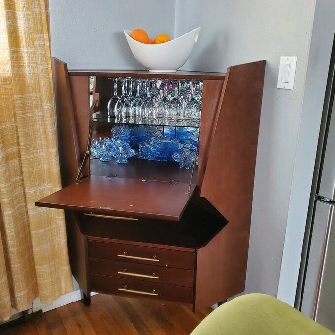 Reviewer photo of a wooden corner bar cabinet with a foldable shelf