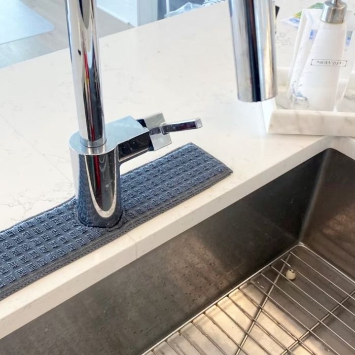 A cloth drip catcher placed around the base of a kitchen faucet