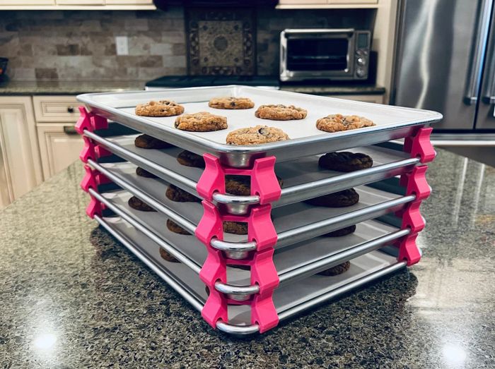 Baking sheets neatly stacked with pink dividers and cookies placed on them
