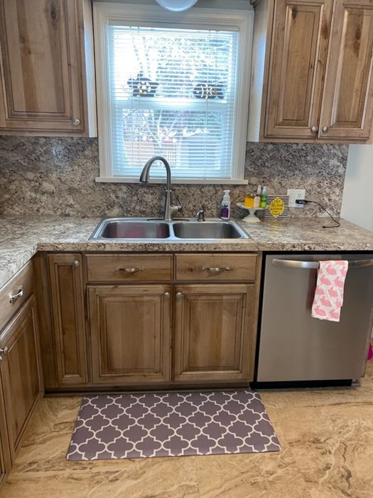 The reviewer’s anti-fatigue mat resting on the floor in front of a kitchen sink