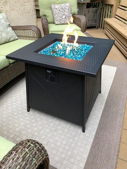 A reviewer’s fire pit glowing warmly on their patio.
