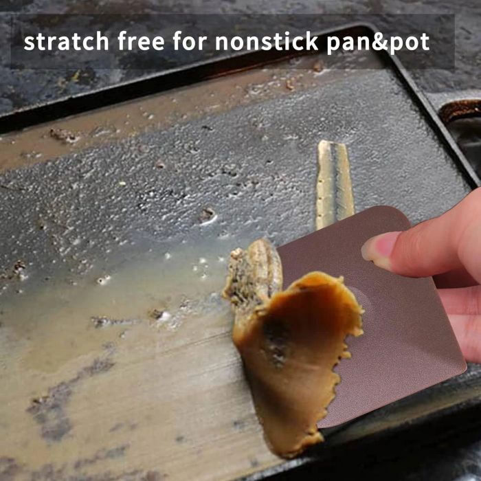 Scraping off cooked-on residue from a nonstick griddle with a cleaning tool.