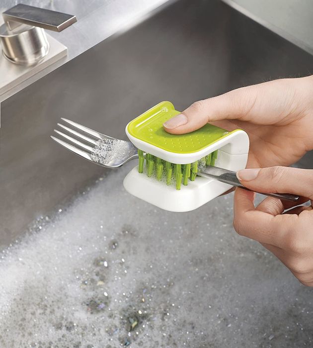 A model washing a fork with an utensil cleaner