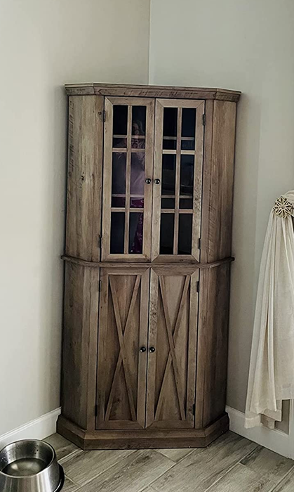 Image of a brown wooden corner cabinet positioned against a wall