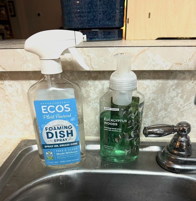 Two cleaning bottles placed next to a sink: one ECOS dish spray and one Eucalyptus Woods hand soap