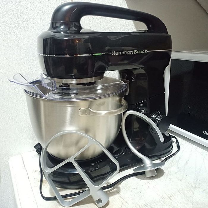 A reviewer photo showing the black stand mixer with its included attachments