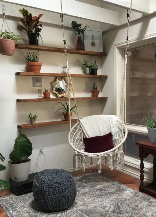 Reviewer's hammock chair hanging in their living room, next to some plants.